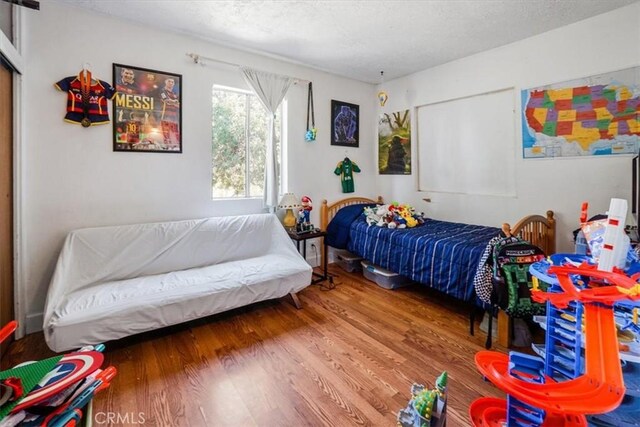 bedroom with wood-type flooring and a textured ceiling