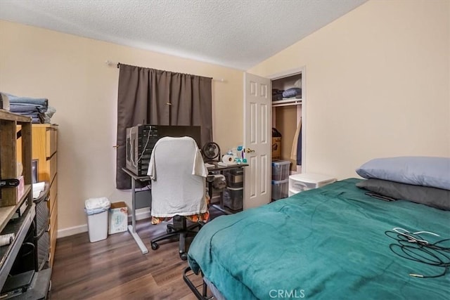 bedroom with hardwood / wood-style flooring, vaulted ceiling, a textured ceiling, and a closet