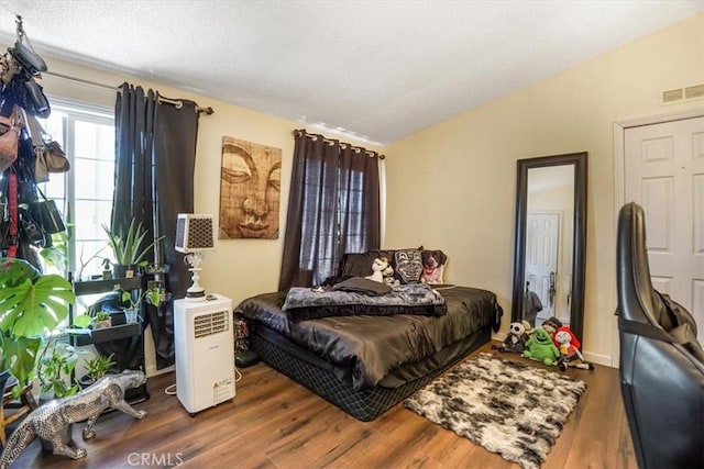 bedroom with vaulted ceiling and hardwood / wood-style floors