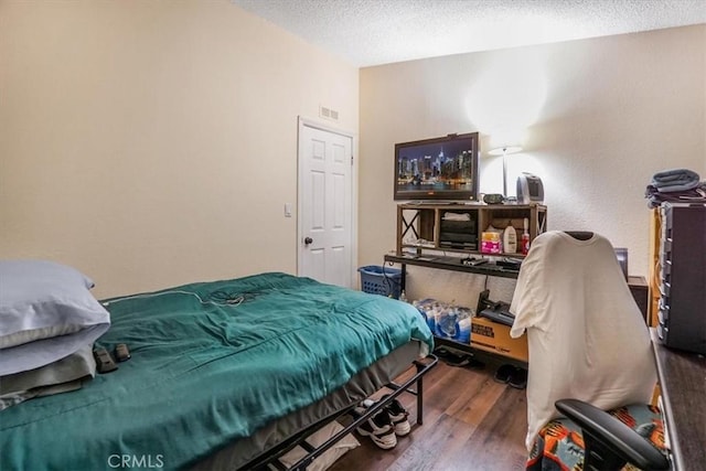 bedroom featuring dark wood-type flooring and a textured ceiling