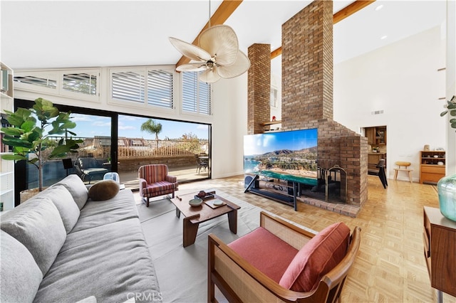 living room with ceiling fan, high vaulted ceiling, light parquet flooring, and a brick fireplace