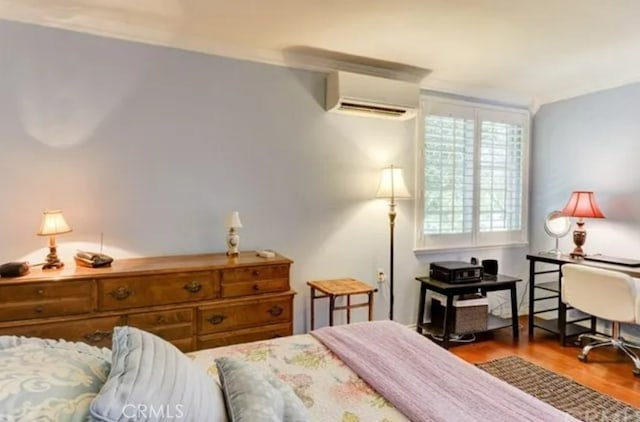 bedroom featuring hardwood / wood-style flooring and a wall unit AC