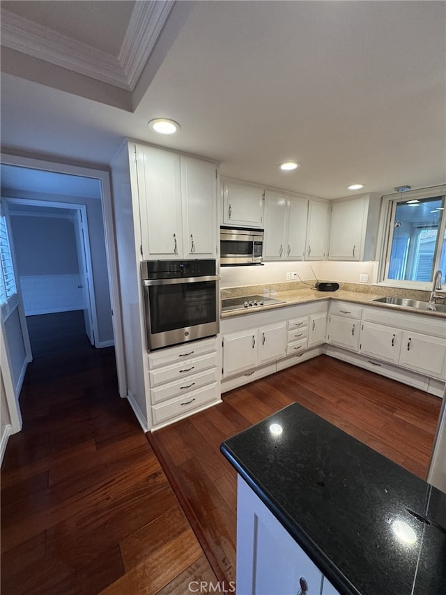 kitchen featuring stainless steel appliances, dark hardwood / wood-style flooring, sink, and white cabinets