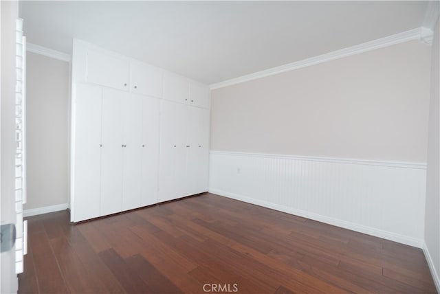 394 Avenida Castilla Unit F, Laguna Woods, CA 92637 - unfurnished bedroom featuring dark wood finished floors, crown molding, a closet, and wainscoting