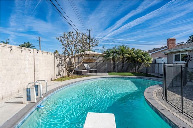 view of swimming pool featuring a diving board