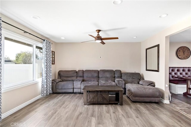 living room featuring wood-type flooring and ceiling fan