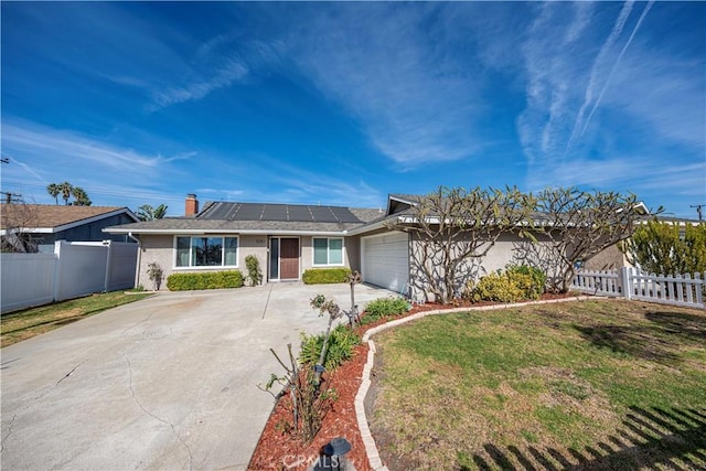 ranch-style home featuring a garage, a front lawn, and solar panels