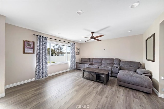 living room with light hardwood / wood-style floors and ceiling fan