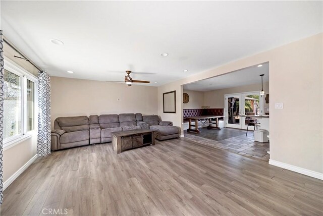 living room with hardwood / wood-style floors, ceiling fan, and french doors