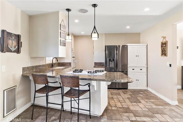 kitchen featuring hanging light fixtures, a breakfast bar, white appliances, and kitchen peninsula