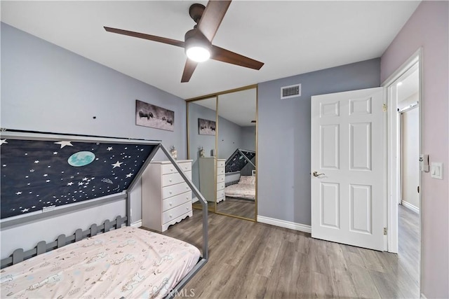 bedroom with hardwood / wood-style flooring, a closet, and ceiling fan