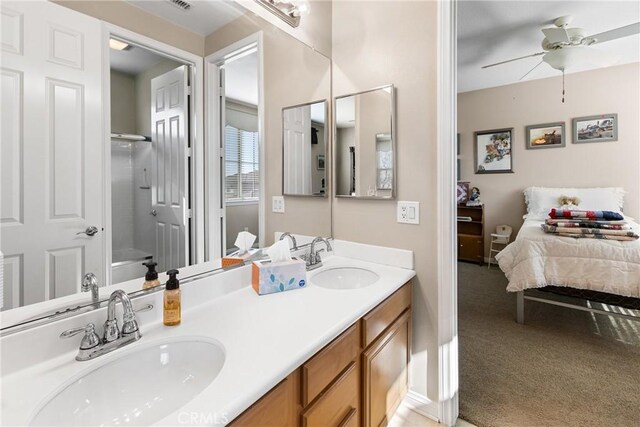 bathroom with a shower with door, vanity, and ceiling fan