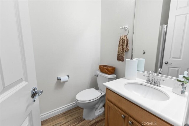 bathroom with hardwood / wood-style flooring, vanity, and toilet