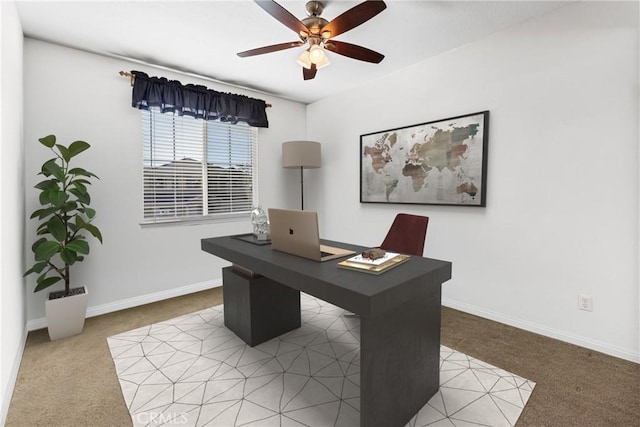 carpeted home office with a ceiling fan and baseboards