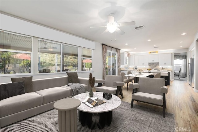 living room featuring recessed lighting, visible vents, light wood-style flooring, and ceiling fan