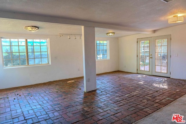 unfurnished room with a textured ceiling and french doors