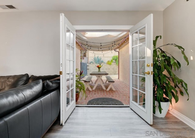 doorway with wood-type flooring and french doors