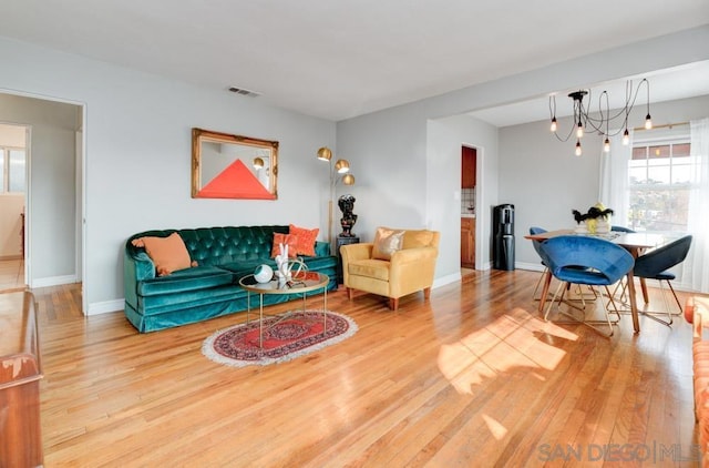 living room with hardwood / wood-style floors and a notable chandelier