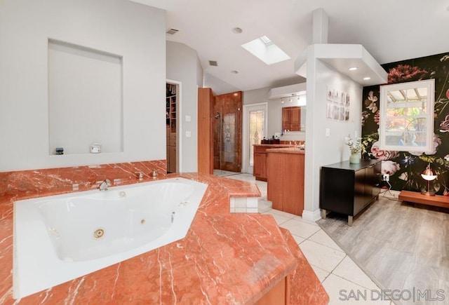 bathroom featuring vanity, a skylight, tile patterned floors, and independent shower and bath