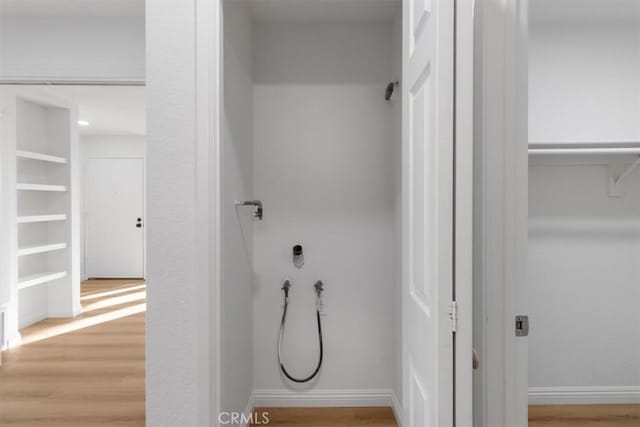 washroom featuring hardwood / wood-style flooring, hookup for a washing machine, and built in features