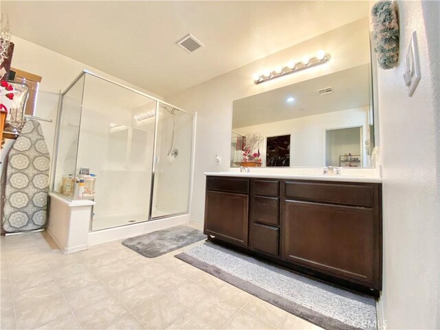 bathroom with vanity and a shower with door