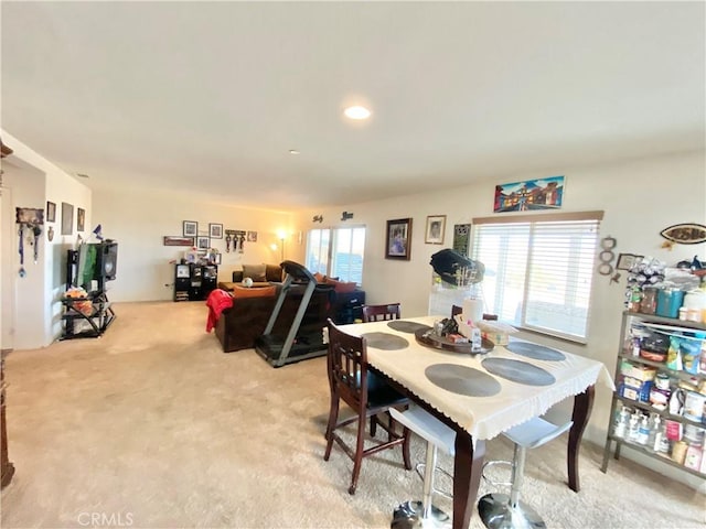 dining space with plenty of natural light and light carpet