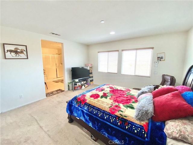 bedroom with ensuite bath and carpet