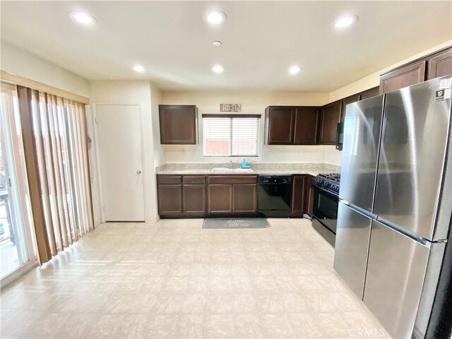 kitchen featuring dark brown cabinets, sink, and black appliances