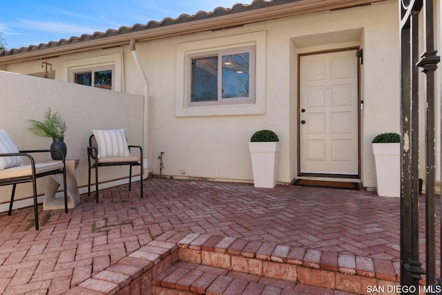 view of exterior entry featuring a patio area