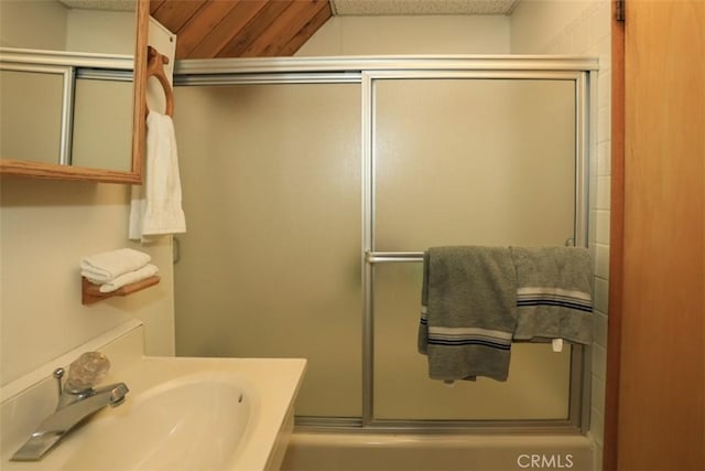 bathroom featuring an enclosed shower and sink