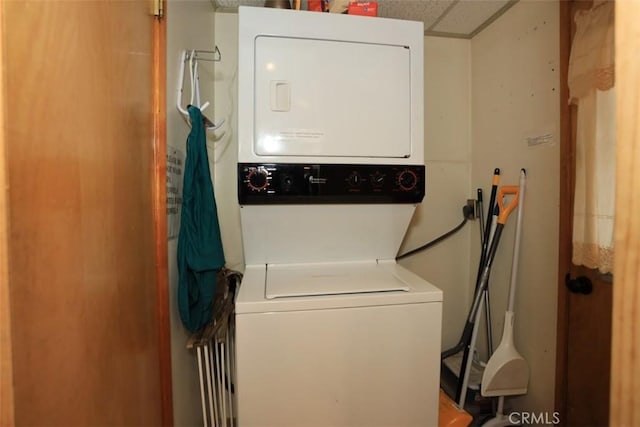 clothes washing area featuring stacked washer / dryer