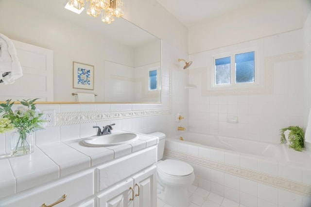 full bathroom featuring toilet, tasteful backsplash, an inviting chandelier, vanity, and tiled shower / bath combo