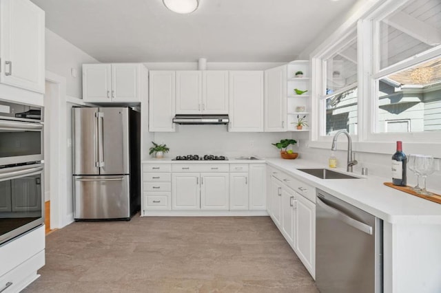 kitchen featuring stainless steel appliances, white cabinetry, and sink