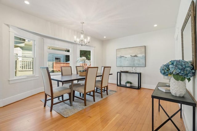 dining room featuring a notable chandelier, a healthy amount of sunlight, and light wood-type flooring