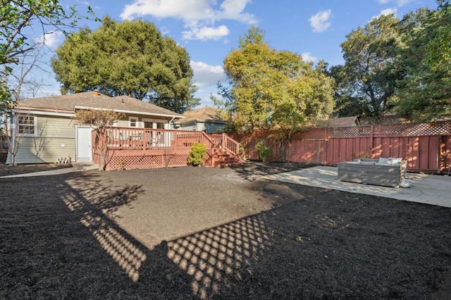 view of yard featuring an outdoor living space, a patio, and a deck