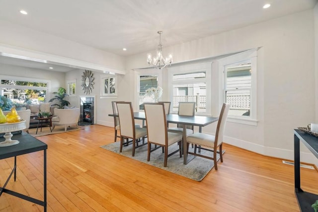 dining area with an inviting chandelier and light hardwood / wood-style flooring