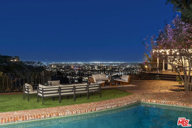 pool at twilight featuring an outdoor living space