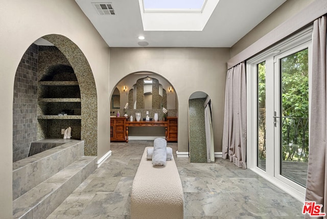 interior space featuring a washtub, decorative backsplash, and a skylight