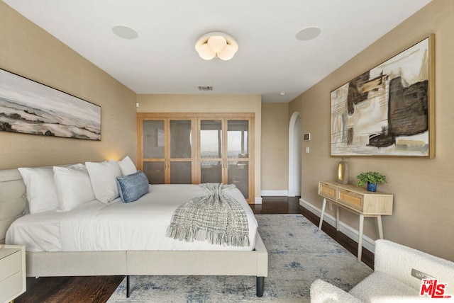 bedroom with dark hardwood / wood-style floors