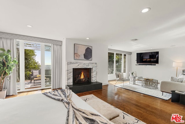 living room featuring wood-type flooring and a premium fireplace