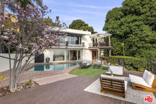 back of house featuring a pergola, outdoor lounge area, a balcony, and a swimming pool side deck