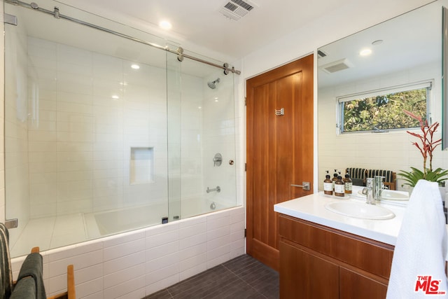 bathroom with enclosed tub / shower combo and vanity