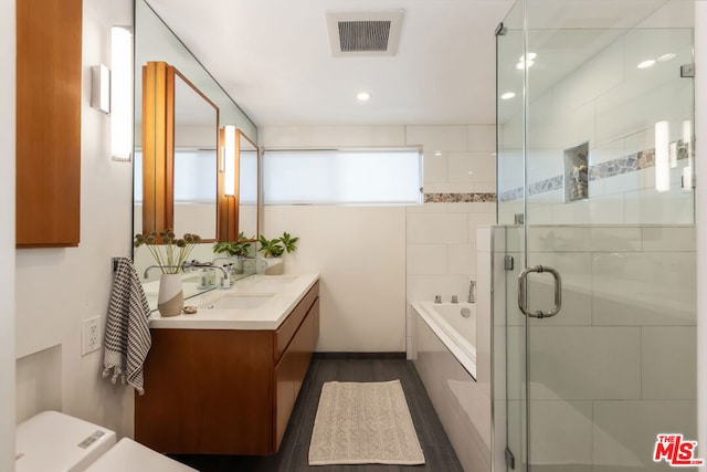 bathroom with shower with separate bathtub, wood-type flooring, and vanity