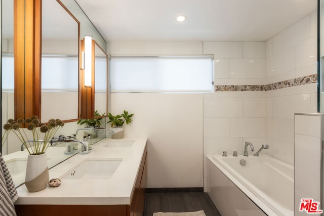 bathroom featuring hardwood / wood-style flooring, vanity, a bathing tub, and a wealth of natural light