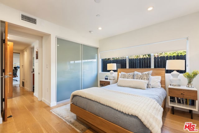 bedroom with a closet and light hardwood / wood-style flooring