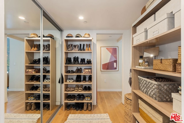 walk in closet with light wood-type flooring