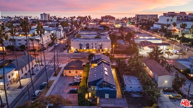 aerial view at dusk featuring a water view