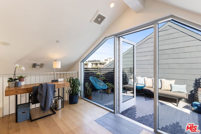 doorway to outside featuring hardwood / wood-style flooring and vaulted ceiling