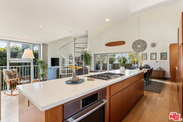 kitchen featuring light wood-type flooring, plenty of natural light, a center island, and appliances with stainless steel finishes