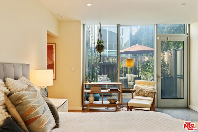 bedroom with floor to ceiling windows and light wood-type flooring